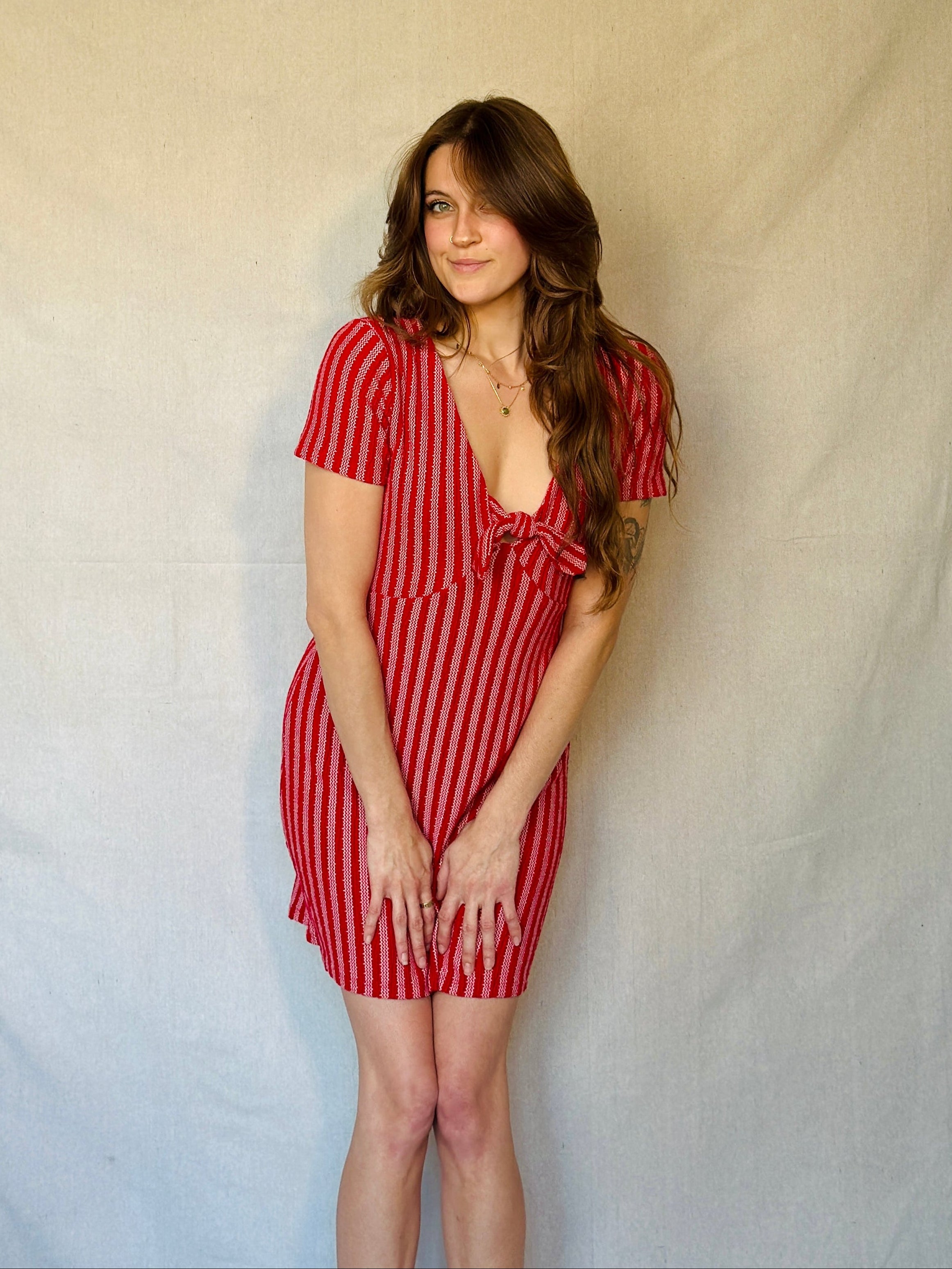 Woman wearing a red striped dress against a plain background