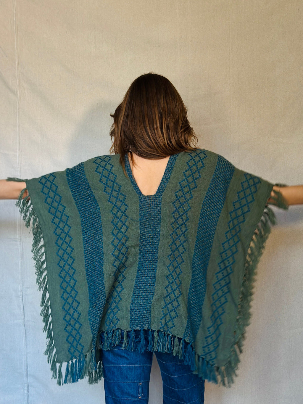 Person wearing a green poncho with a white background