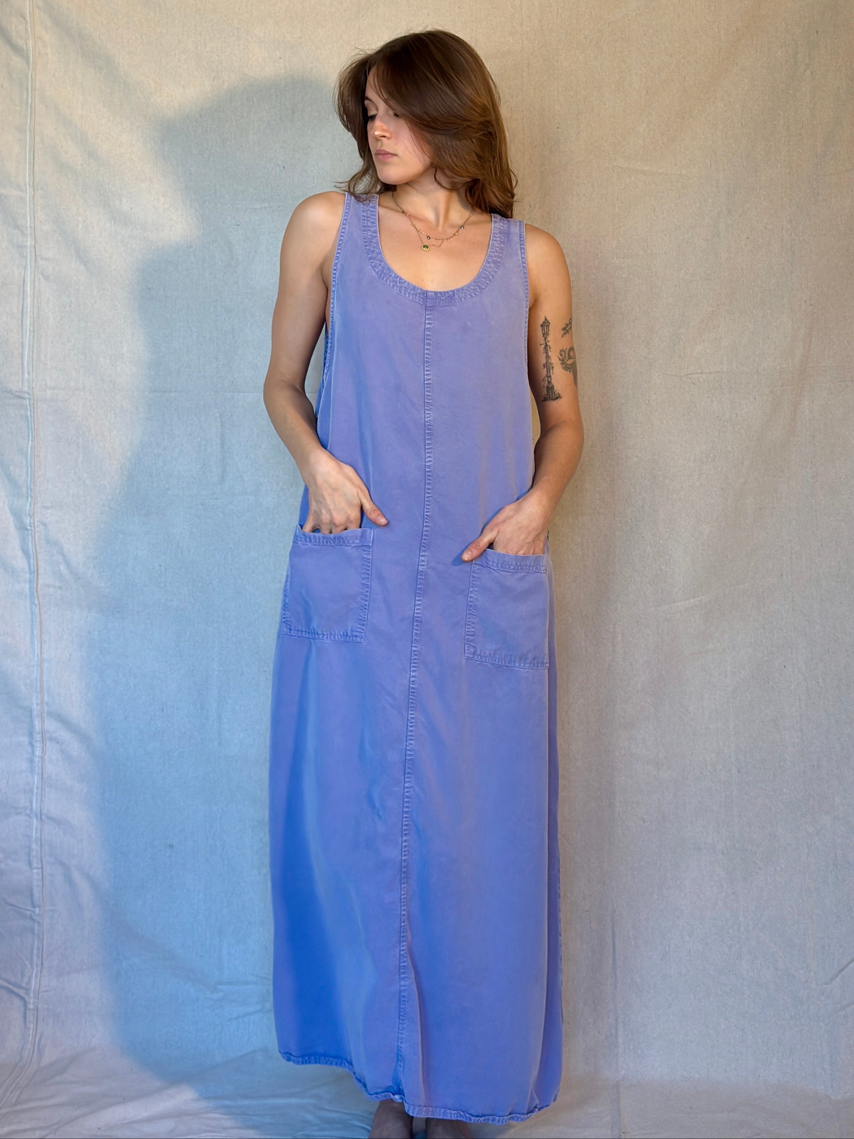 Woman wearing a long purple dress against a plain background